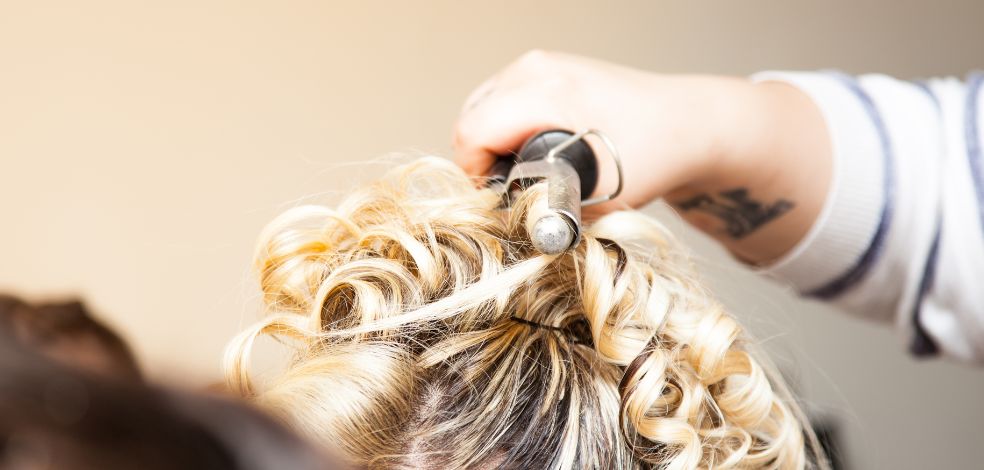 fryzjer stylizuje włosy przyszłej panny młodej